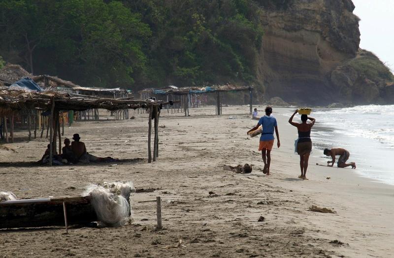 People walking on tan sand beach in Cartagena