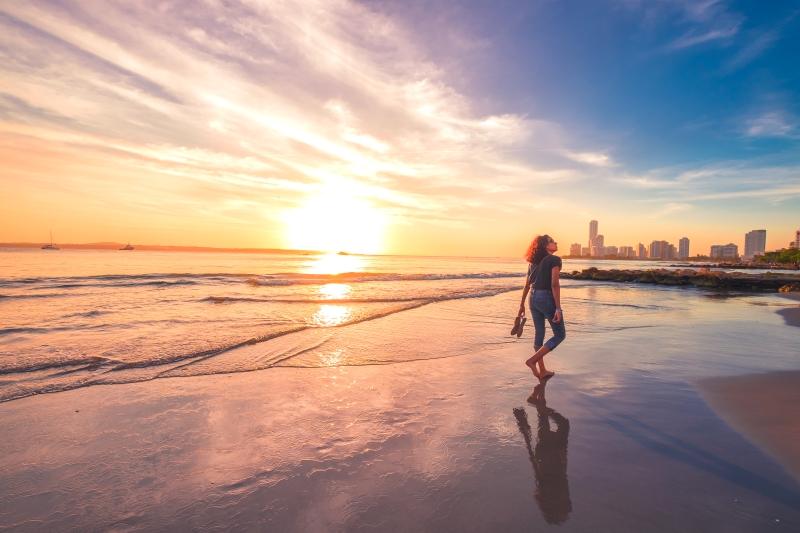 Woman walking at sunset at city beach in Cartagena