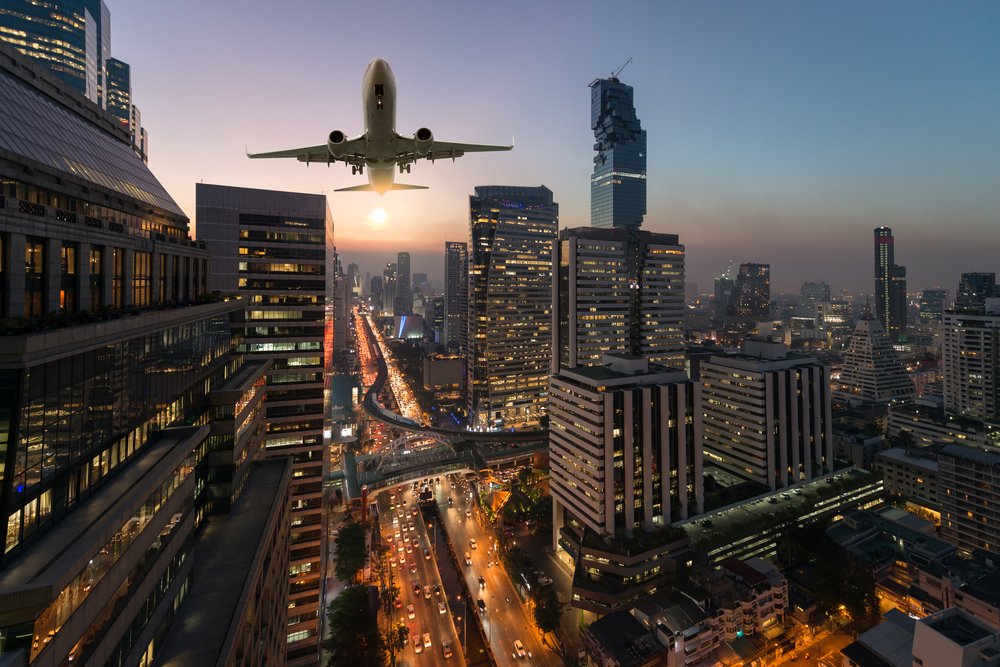 plane flying over Bangkok at twilight